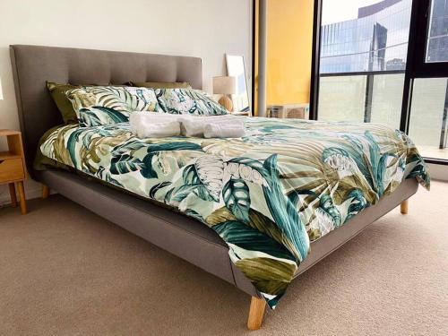 a bed in a room with a bedskirtspectspectspects at Lovely 1BR Apartment - Free Parking in Melbourne