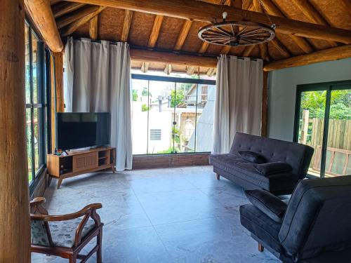 a living room with a couch and a tv at Casa com piscina em Torres in Torres