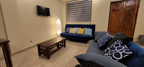 ein Wohnzimmer mit einem blauen Sofa und einem Tisch in der Unterkunft Wild Orchid 5BHK Villa & Eco Cottages in Sancoale Valley in Sancoale