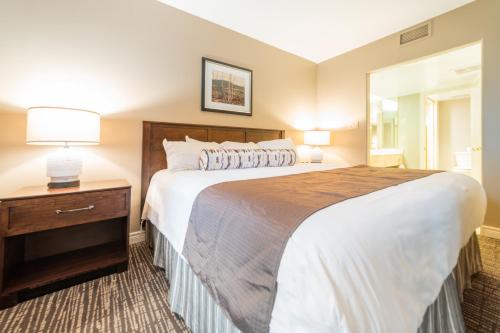 a bedroom with a large bed and a dresser with a mirror at Horseshoe Valley Suites - The Azure in Shanty Bay