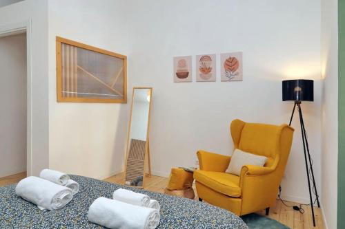 a living room with a yellow chair and a table at Gazometro Apartment SelfCheck-in in Rome