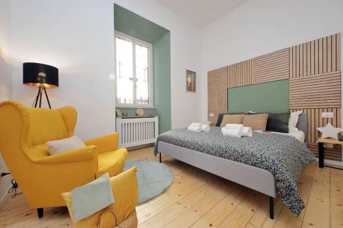 sypialnia z łóżkiem i żółtym krzesłem w obiekcie Gazometro Apartment SelfCheck-in w Rzymie