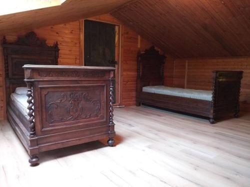 una camera con due letti in una cabina di legno di Shangri-La a Villar Pellice