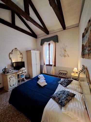 a bedroom with a large bed with blue sheets at Locanda Ca' Formosa in Venice