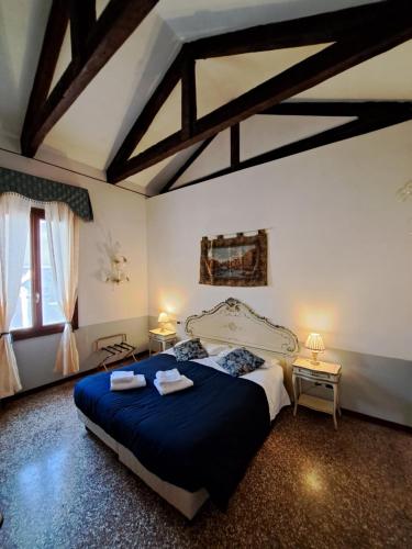 1 dormitorio con 1 cama grande y edredón azul en Locanda Ca' Formosa, en Venecia