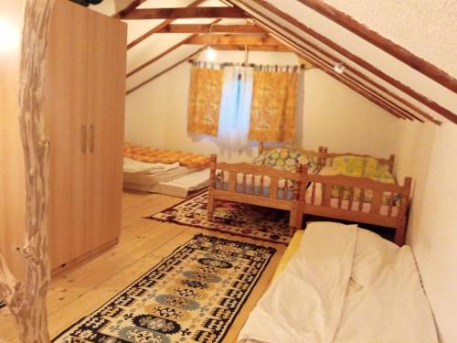 a room with a bed and a crib in a room at Kuca za odmor Magicna livada in Podgrab