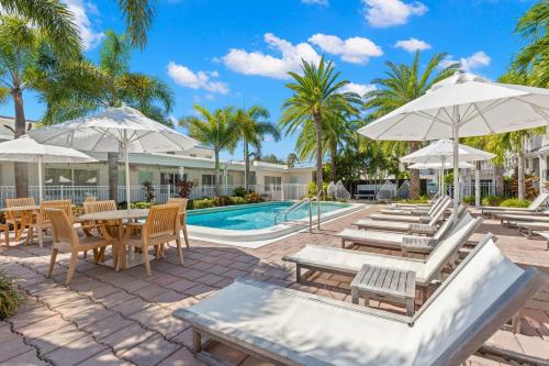 uma piscina com mesas, cadeiras e guarda-sóis em Hotel Cabana Clearwater Beach em Clearwater Beach