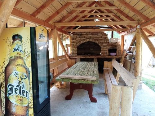 a picnic table and a bottle of beer in a pavilion at Kuca za odmor Magicna livada in Podgrab