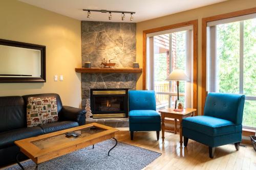 a living room with a couch and a fireplace at Polar Peak Lodges by Fernie Central Reservations in Fernie