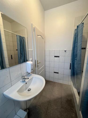 a white bathroom with a sink and a shower at Arsi Hostel in Hamburg
