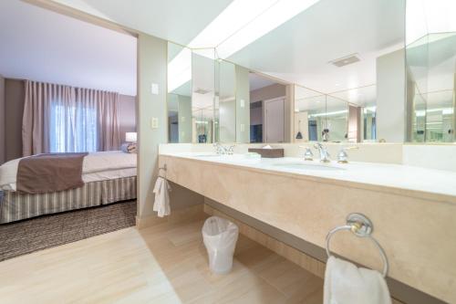 baño con lavabo grande y cama en Horseshoe Valley Suites - The Azure, en Shanty Bay