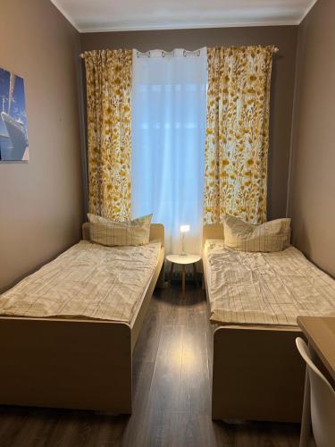 2 Betten in einem Zimmer mit Fenster in der Unterkunft Arsi Hostel in Hamburg