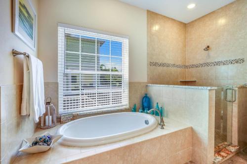 uma grande casa de banho com uma banheira e uma janela em Coconut Cottage em Holmes Beach