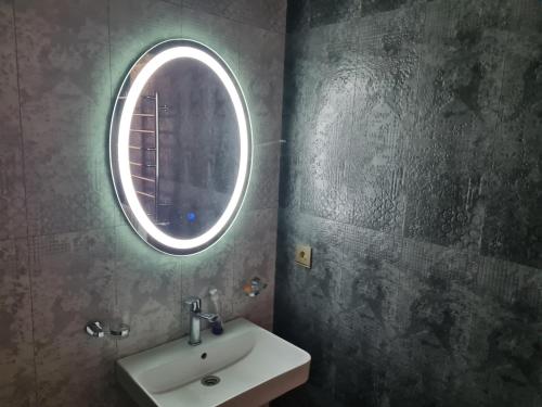 a bathroom with a sink and a round window at Lotus Guesthouse in Fatʼmayy