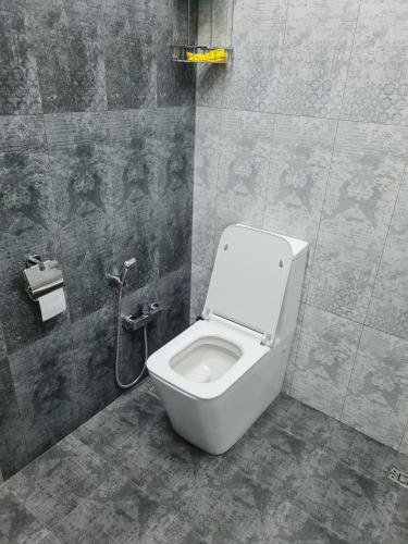 a bathroom with a white toilet in a stall at Lotus Guesthouse in Fatʼmayy