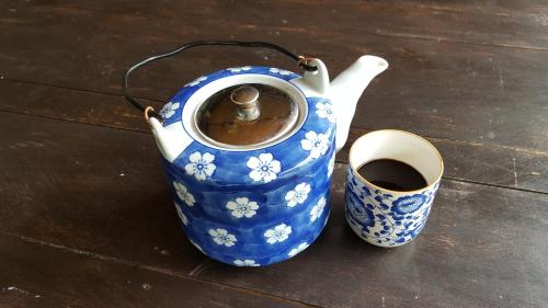 a blue and white vase and a cup of coffee at La Vida Hostel Samal Island in Samal