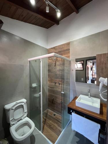 une salle de bains avec douche, toilettes et lavabo dans l'établissement Pousada Las Ondas, à Garopaba