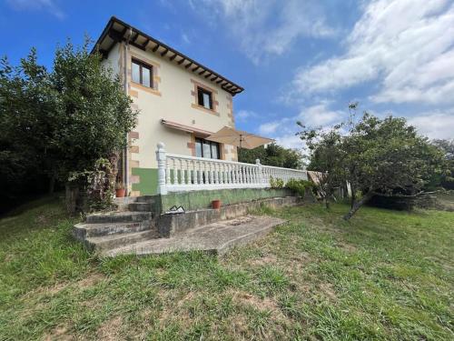 ein Haus mit einem weißen Zaun neben einem Hof in der Unterkunft Casa Musoles in Comillas