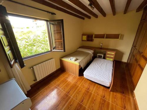 1 Schlafzimmer mit 2 Betten in einem Zimmer mit Fenster in der Unterkunft Casa Musoles in Comillas