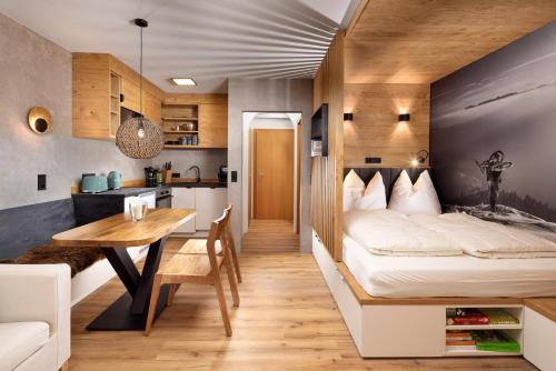 a bedroom with a bed and a table and a kitchen at Königsleiten Ski- und Wanderwohnung Top 40 an der Piste und Lift in Königsleiten