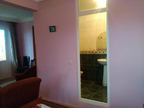 baño con pared rosa con lavabo y espejo en HOTEL - SHORENA en Ureki