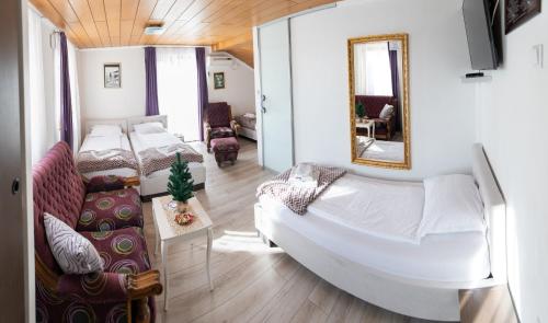 a bedroom with a bed and a mirror and a couch at Guest House Ćiro in Sarajevo