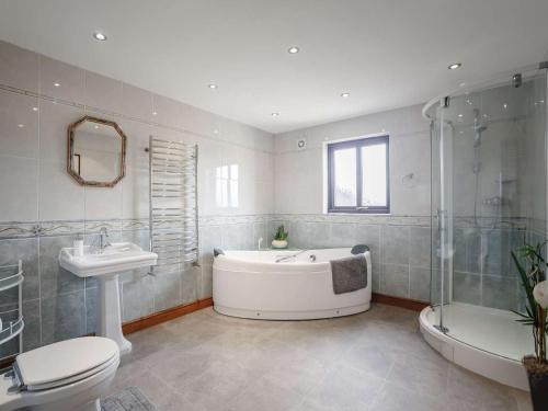 a bathroom with a tub and a toilet and a sink at 3 bed property in Wigton 83471 in Aikton