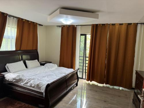 a bedroom with a bed and a large window at Steady State Apartment 1 in Lusaka