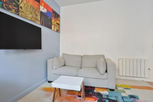 a living room with a couch and a tv at Nice studio with garden near Paris in Vanves - Welkeys in Vanves