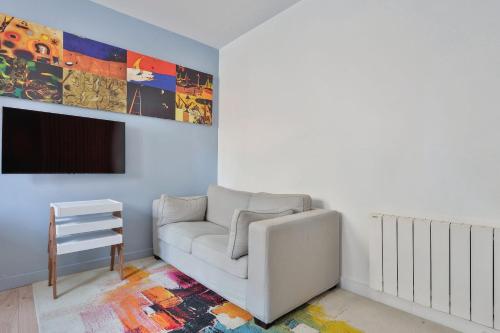 a living room with a white couch and a tv at Nice studio with garden near Paris in Vanves - Welkeys in Vanves