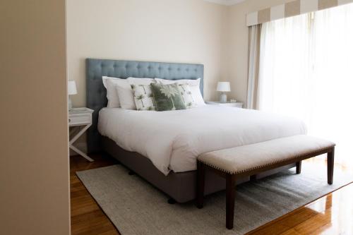 a bedroom with a large bed with a blue headboard at Woodland Bay Retreat-Hot tub,Sauna and Bayview Retreat in Lymington