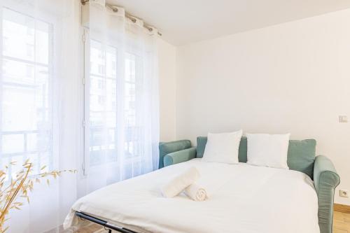 - une chambre blanche avec un lit dans une pièce dotée de fenêtres dans l'établissement L'Emeraude by Plaza - Proche Disneyland Paris, à Chessy