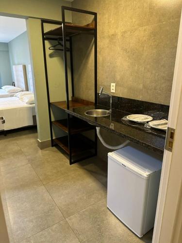 a bathroom with a counter with a sink and a mirror at Ilusion Flat Ponta Negra in Natal
