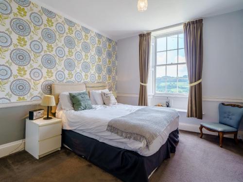 a bedroom with a bed and a chair and a window at 3 Bed in Crosthwaite 75564 in Crosthwaite