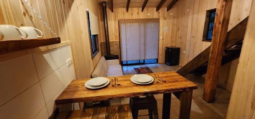 una mesa de madera en el medio de una habitación en Cabaña Alto del Bosque, en Coñaripe