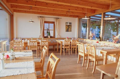 ein Esszimmer mit Holztischen und -stühlen in der Unterkunft Winzerzimmer Scharl in Sankt Anna am Aigen