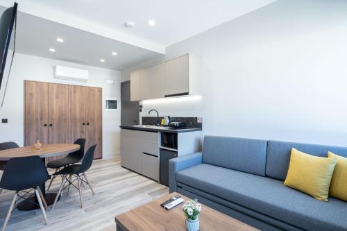 ein Wohnzimmer mit einem blauen Sofa und einem Tisch in der Unterkunft d Suites and Apartments in Ioannina