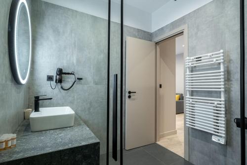 ein Bad mit einem Waschbecken und einem Spiegel in der Unterkunft d Suites and Apartments in Ioannina
