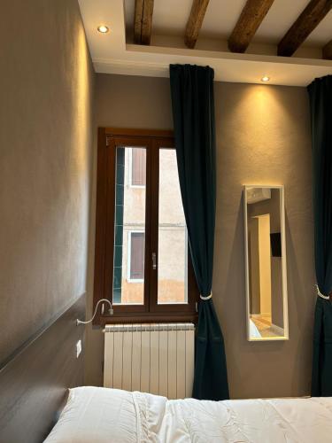a bedroom with a bed and a window with curtains at Ca' Piasentin in Venice