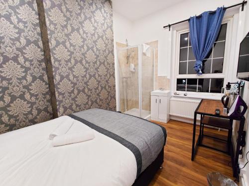 1 dormitorio con cama, ventana y escritorio en Centra Hemel en Hemel Hempstead