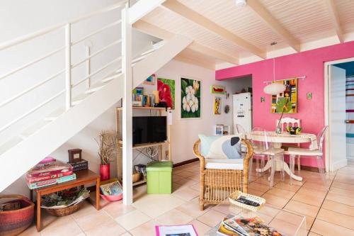 a living room with pink walls and a white staircase at Idyllic Beachfront Condo in Ocho Rios