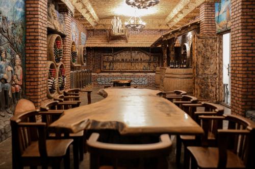 a long wooden table and chairs in a room at Chateau Milisi in Batumi