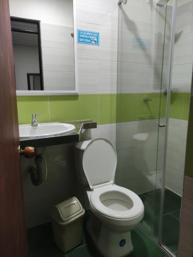 y baño con aseo, lavabo y ducha. en HOTEL KIRPAS, en Villavicencio