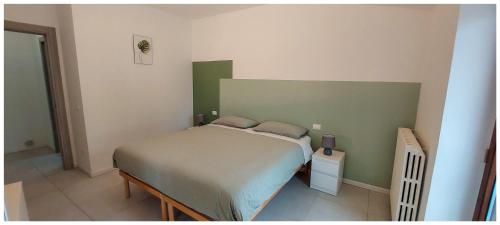 um quarto com uma cama e uma parede verde em Da Titti Appartamento Assisi em Assis