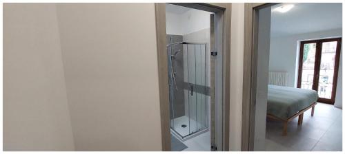 uma casa de banho com chuveiro e uma cama num quarto em Da Titti Appartamento Assisi em Assis