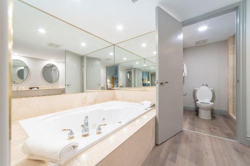 een witte badkamer met een bad en een toilet bij Horseshoe Valley Suites - The Verdant in Shanty Bay