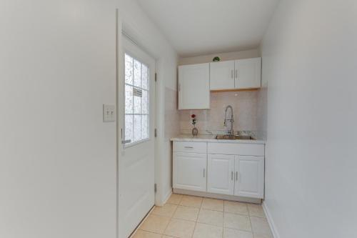 a kitchen with white cabinets and a sink at Cozy Inwood Apartment History, Hiking and Wine! in Inwood