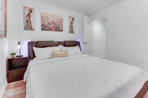 a white bedroom with a large bed with white sheets at Cozy Inwood Apartment History, Hiking and Wine! in Inwood