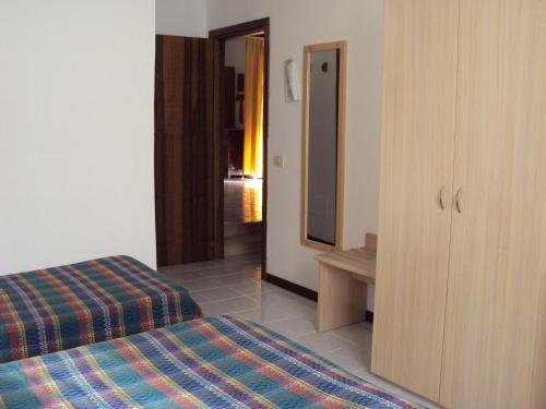 ein Hotelzimmer mit 2 Betten und einem Spiegel in der Unterkunft Hotel Fontanella in Rivotorto