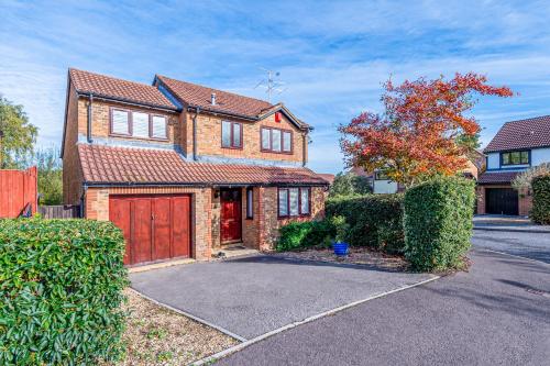 a brown brick house with a red garage at Spacious House, Sleeps 7 people in Reading